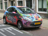 838198 Afbeelding van een Ford-personenauto, volgespoten met graffiti, op de Laan van Engelswier te Utrecht.